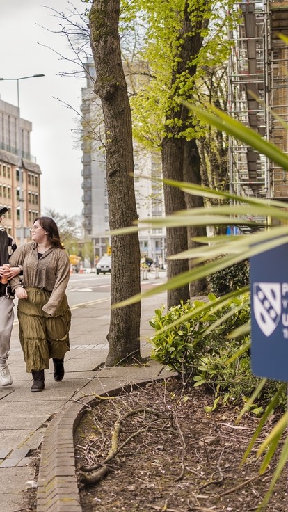 Four students walking outside Cardiff campus