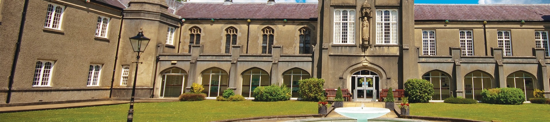 Fountain in centre of Lampeter old building on sunny day
