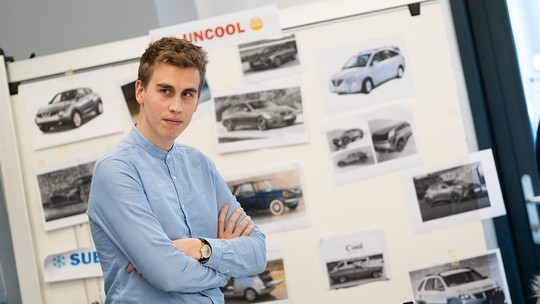 Student standing in front of a display of their work