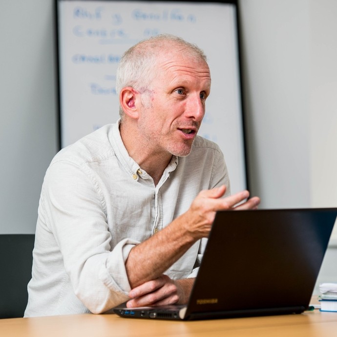 Staff member in discussion with laptop in front of him