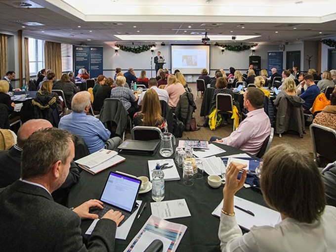a group of people listening to a conference