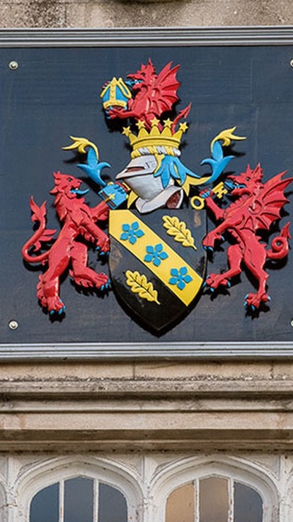 Brightly painted UWN coat-of-arms on the wall of the college in Lampeter.