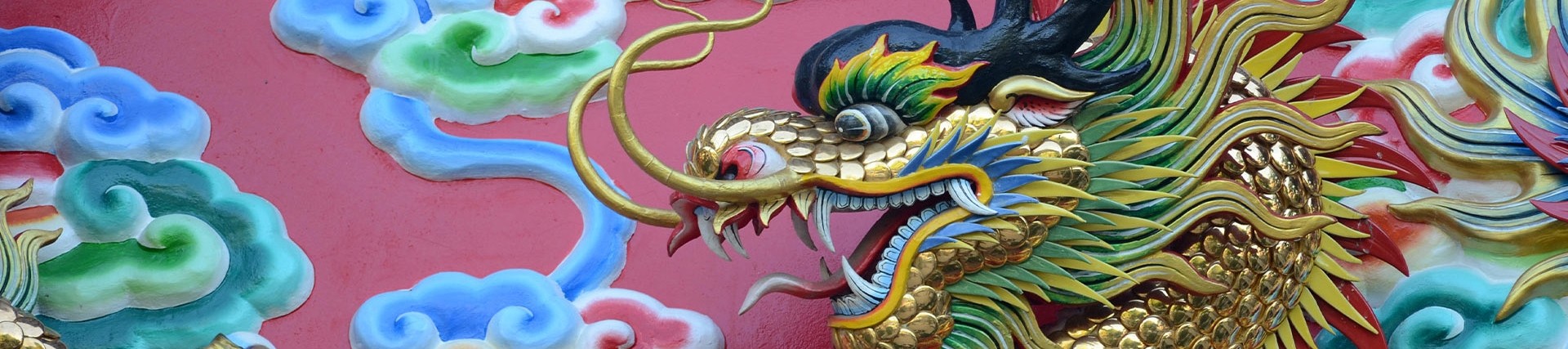A painted carving of a Chinese dragon with gilt scales.