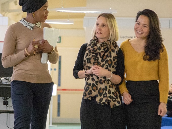 Three staff members walking and in discussion