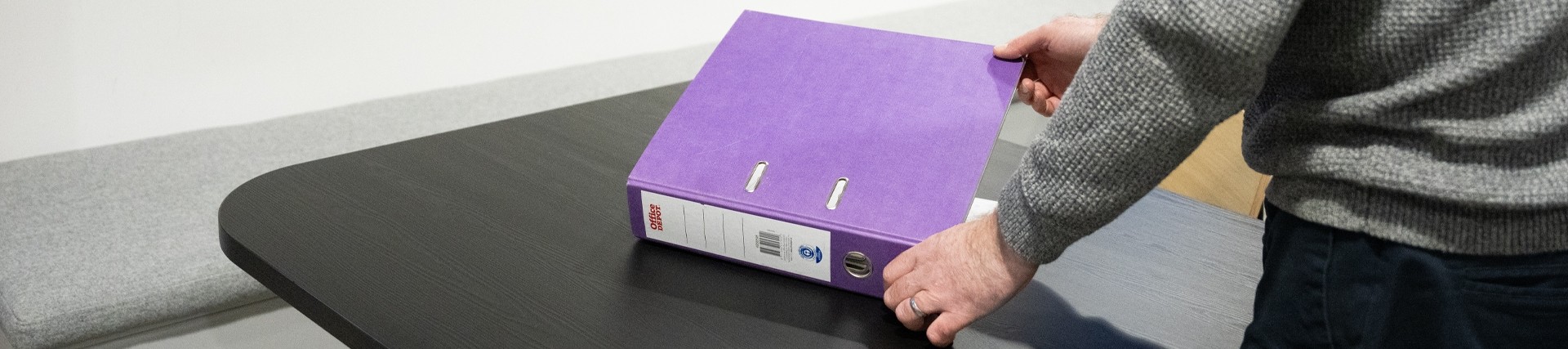 Person opening a purple ring binder