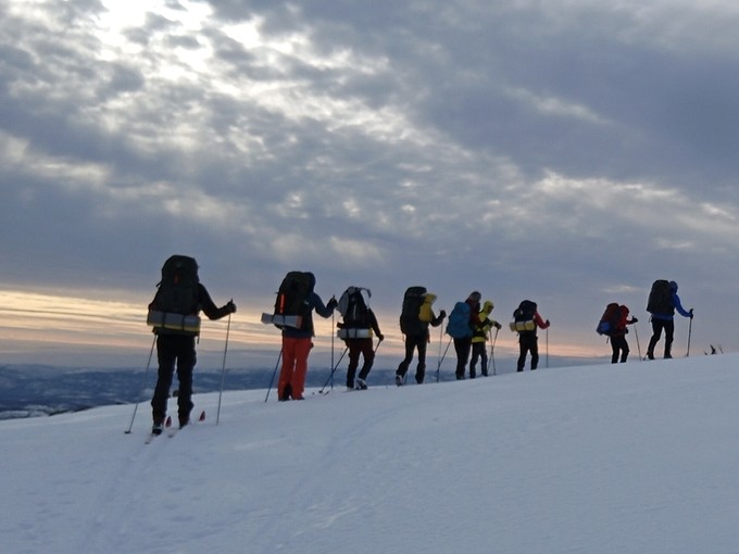 Students walking on snow-capped mountain
