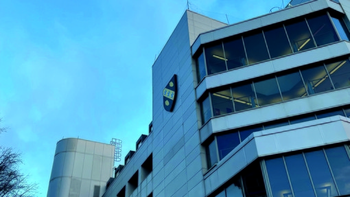 Image of Swansea Business Campus, a grey building with glass windows under blue skies
