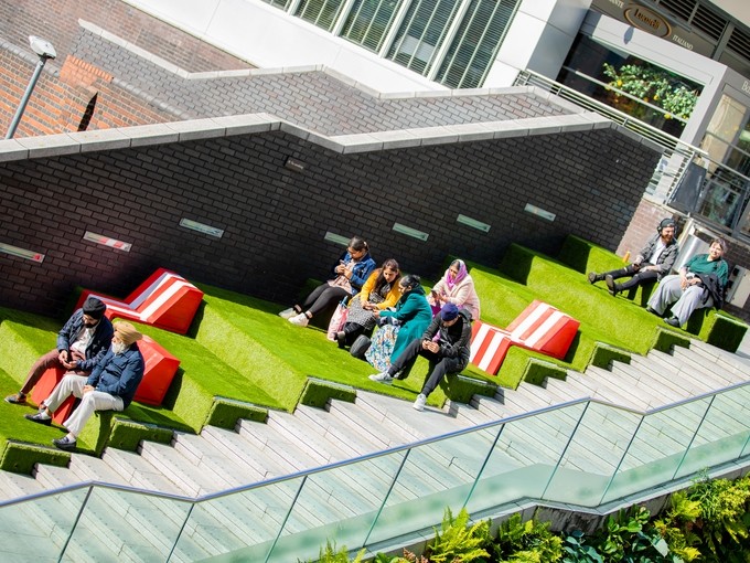 People sitting and relaxing on grass covered steps