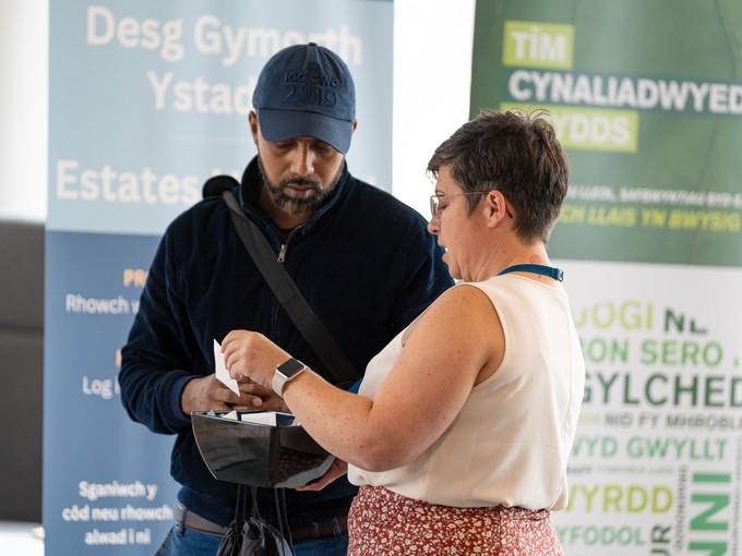 Staff member assisting a potential student at a fair
