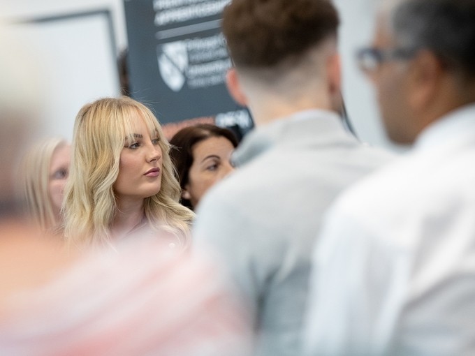 Group of people at an exhibition with one person in focus